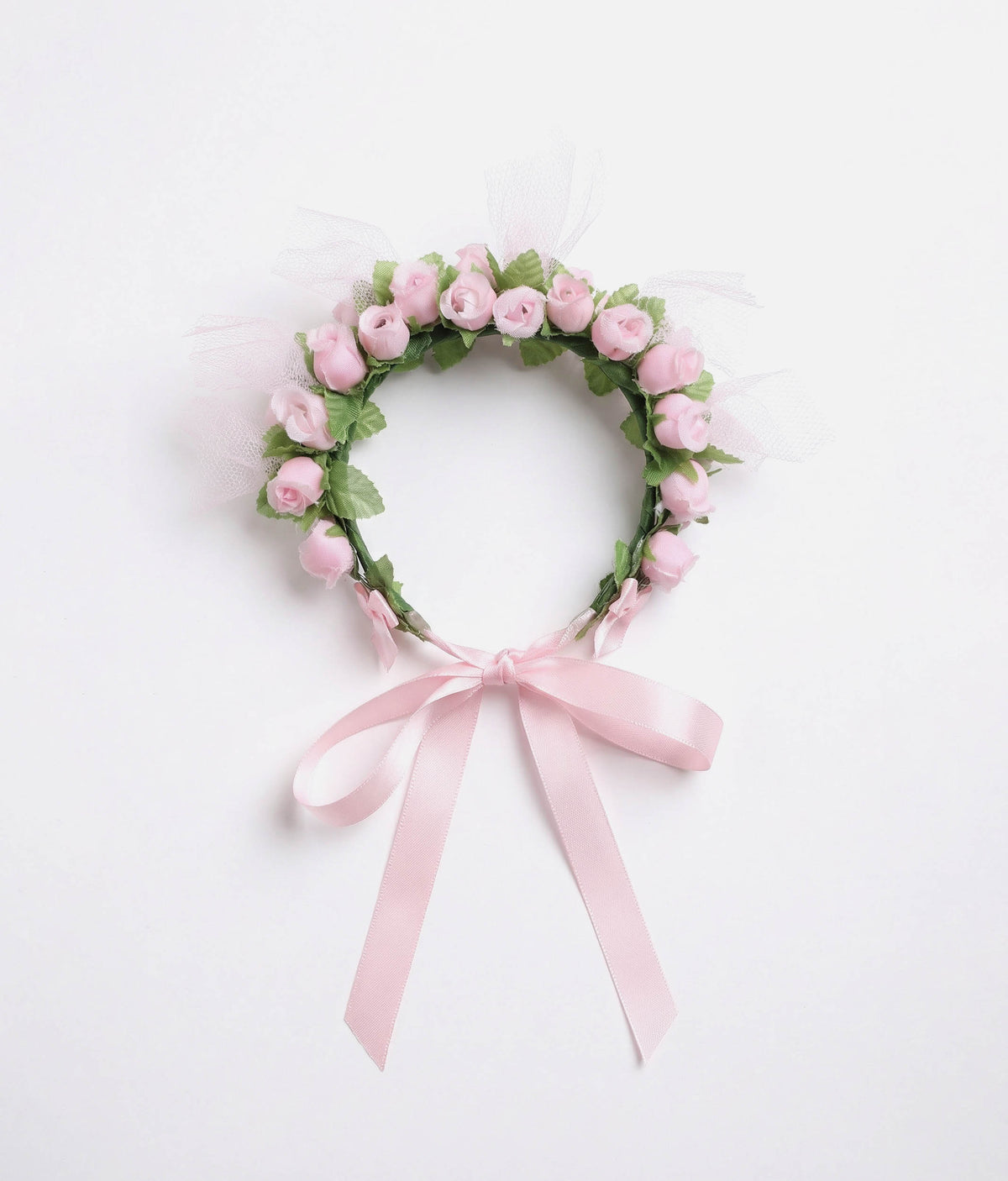 Ballerina with a floral hair accessory and pink dress on a plain background 