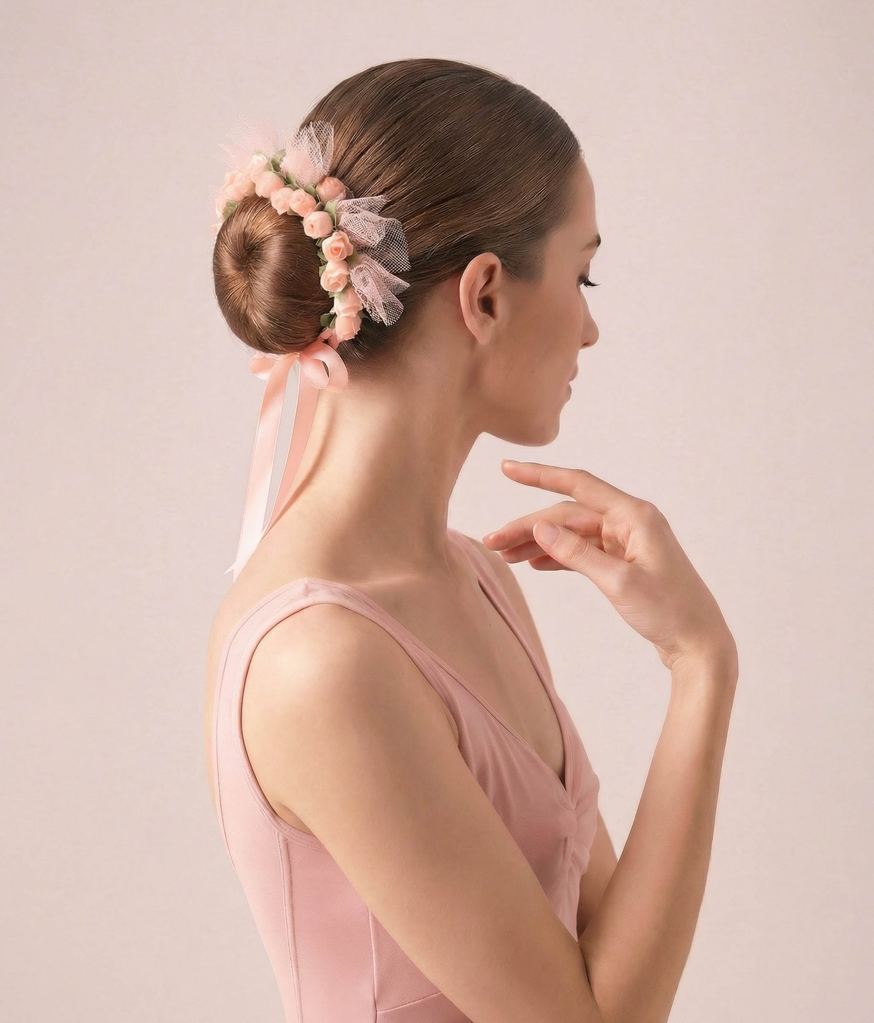 Ballerina with a floral hair accessory and pink dress on a plain background 