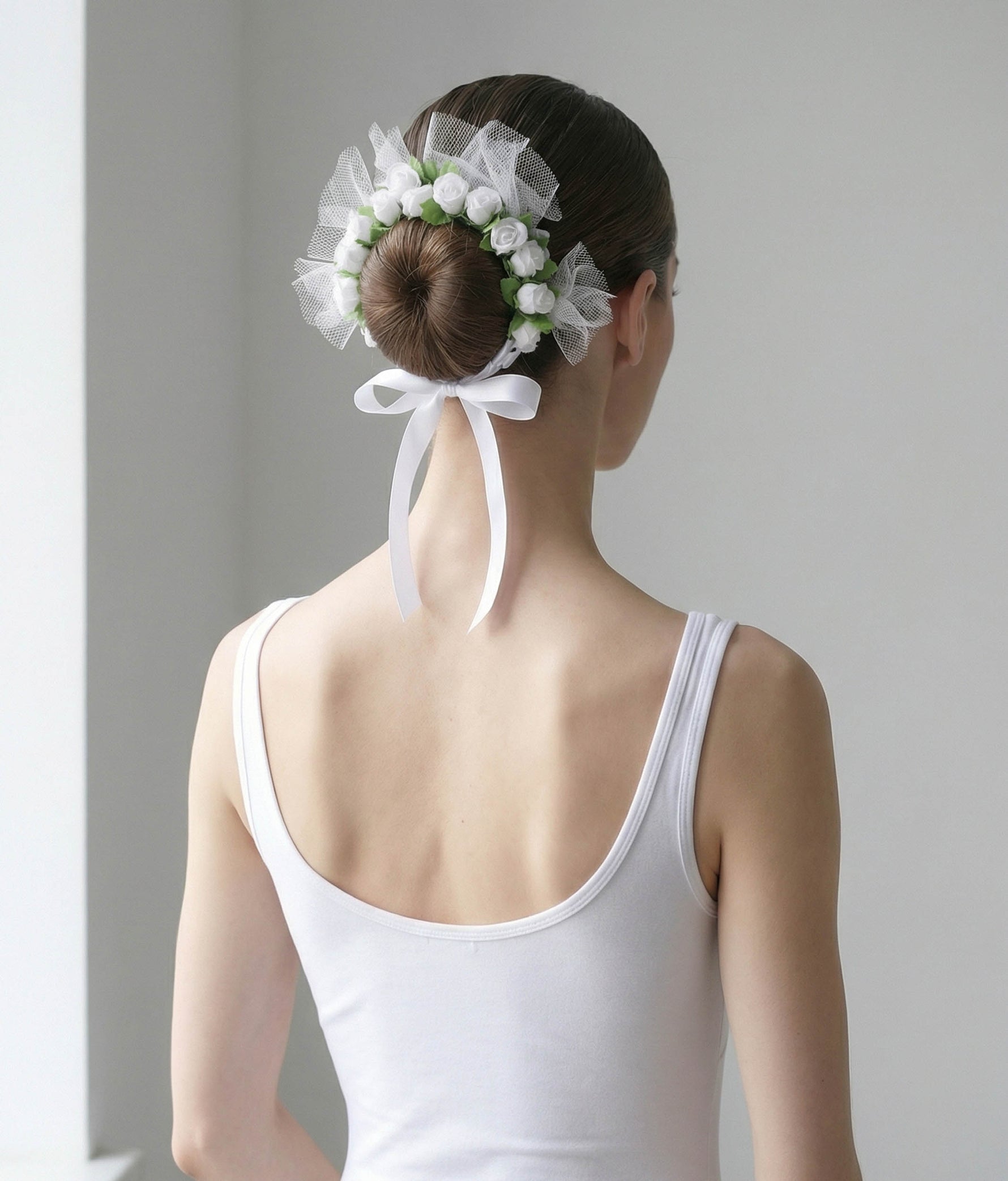 Ballerina with a floral hair accessory and pink dress on a plain background 