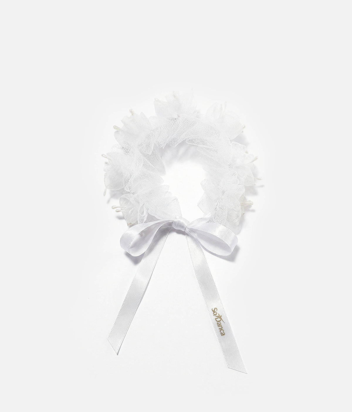 Woman wearing a white floral hair accessory with a plain background 