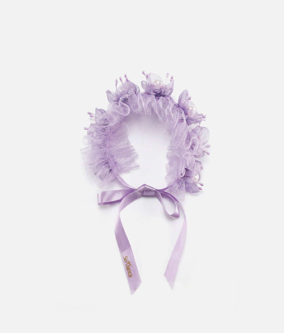 Woman wearing a lilac floral hair accessory with a plain background 