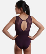 Woman wearing a purple leotard with mesh panels on a white background 